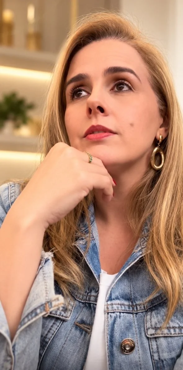 Geyza Nogueira pensativa, com a mão no queixo